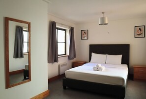 2 habitaciones, escritorio y tabla de planchar con plancha