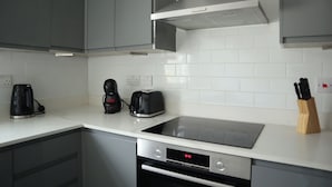 A modern kitchen with grey cabinets, a Bosch oven, a toaster, and a coffee maker.