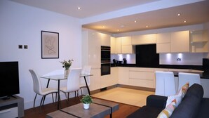 Un apartamento moderno con comedor, sala de estar con sofá y cocina.