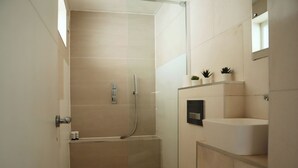 Un baño moderno con cabina de ducha, inodoro y lavabo.