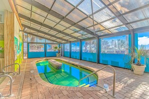 Piscina techada con vista a palmeras y al paisaje urbano.