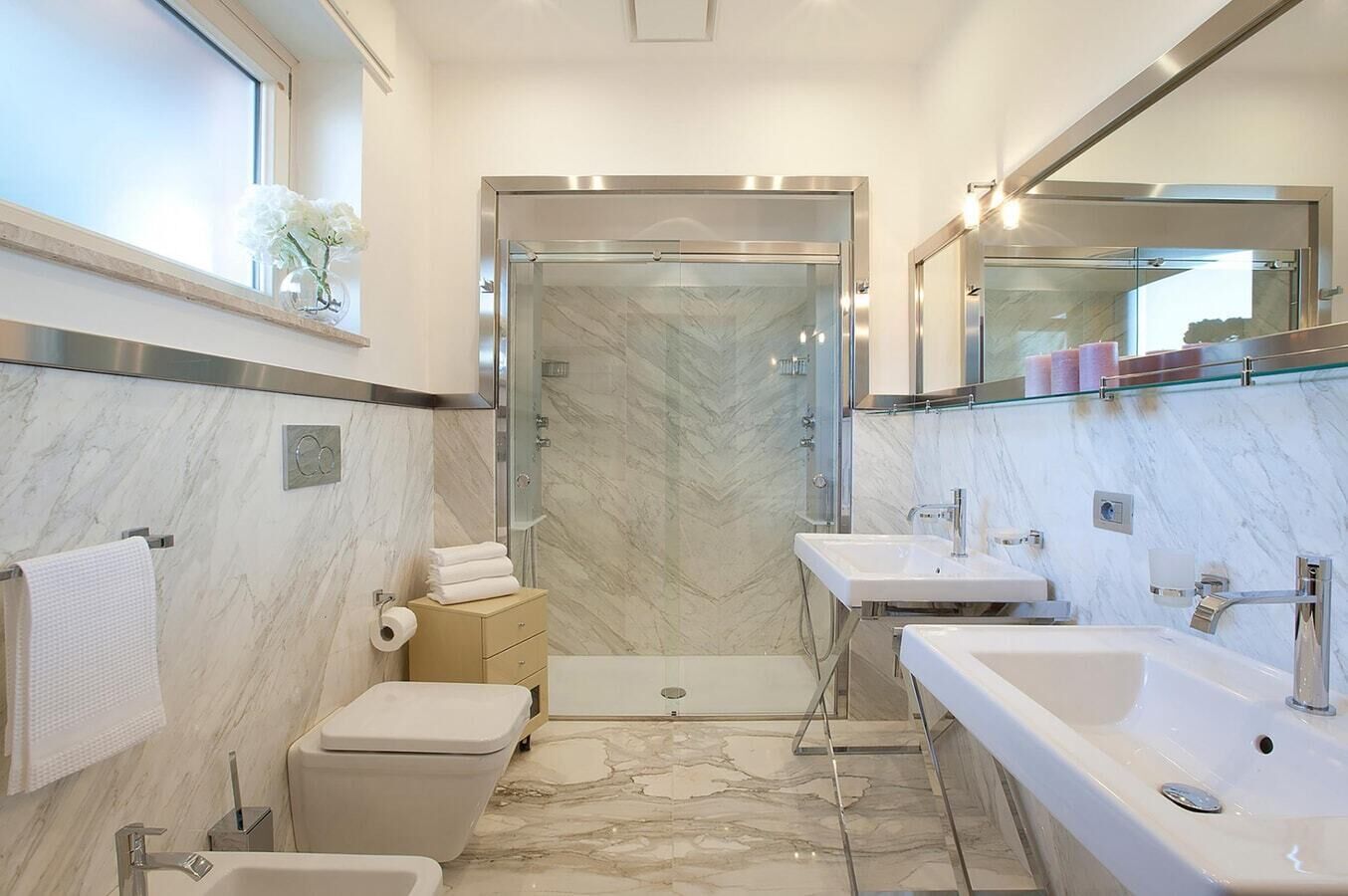 Ein modernes Badezimmer mit Dusche, Toilette und zwei Waschbecken.
