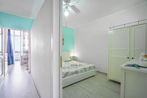 Een slaapkamer met een bed, een kledingkast, een bureau en een badkamer, zichtbaar door een open deur.