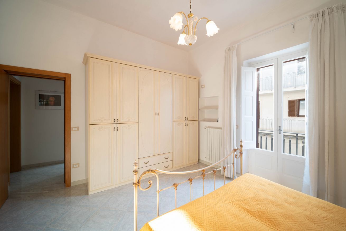 Un dormitorio con cama, armario y ventana con vistas.