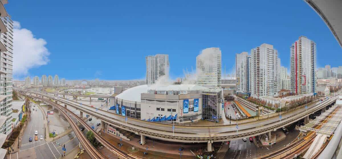 A modern urban area with high-rise buildings, a large stadium, and a complex highway interchange.