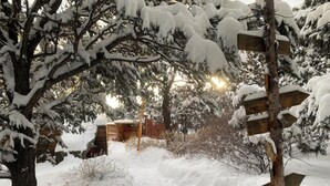 Uma área externa coberta de neve, com um painel de madeira e uma estrutura de madeira ao fundo.