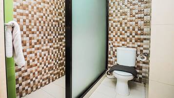 A bathroom with a checkered tile wall, a toilet, and a towel rack.