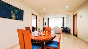 A dining area with a round table, chairs, and a painting on the wall. - UTC Dago Hotel Bandung (Bandung)