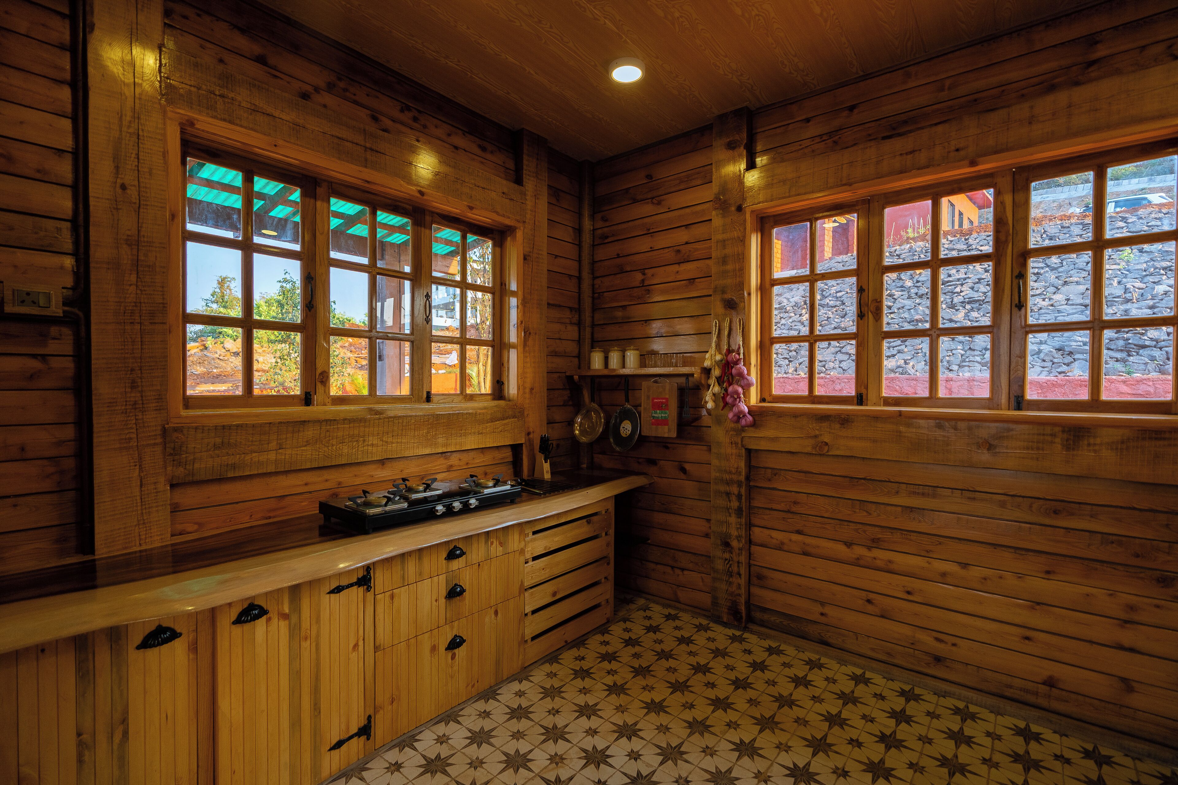 A wooden interior with a kitchen area, including a stove and cabinets.