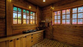A wooden interior with a kitchen area, including a stove and cabinets.