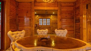 A wooden interior with a round table and four upholstered chairs. - Villa 107 Amarja's Citadel Nest (Mawal)