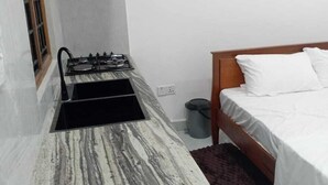 A compact kitchen with a gas stove, a sink, and a marble countertop. - Lanka Global  (Jaffna)
