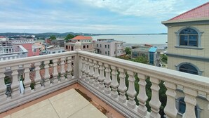 Un balcón con vistas a un paisaje urbano y una masa de agua.