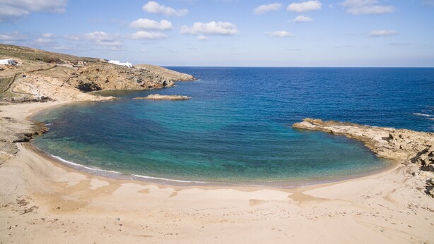 A coastal landscape with a sandy beach, clear blue waters, and rocky cliffs. - Seaside 5BDR Bliss in Mykonos (Mikonos)