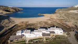 A coastal resort with white buildings, a sandy beach, and a clear blue sea. - Seaside 5BDR Bliss in Mykonos (Mikonos)