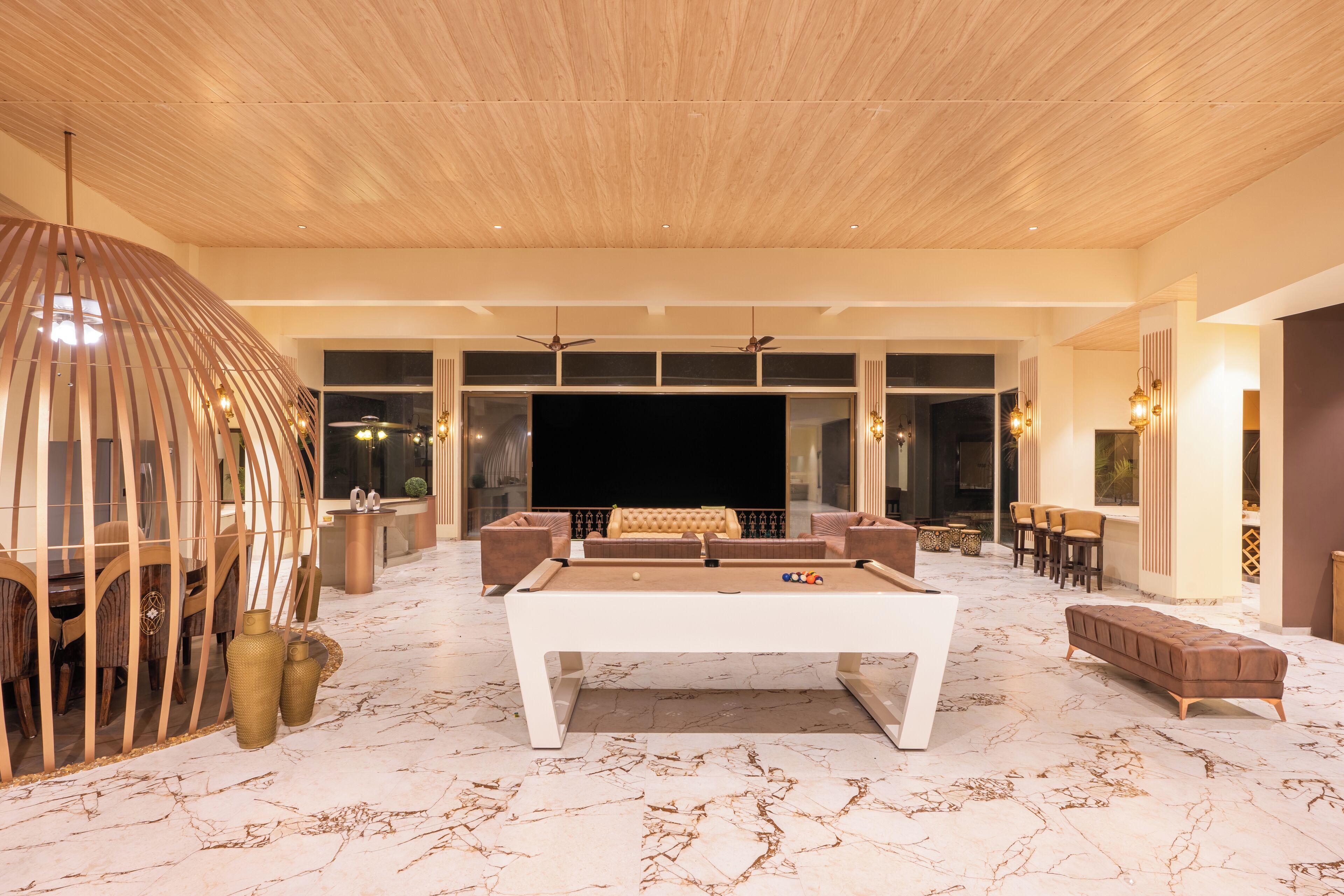 A spacious living area with a pool table, comfortable seating, and a large TV screen.