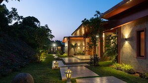 A modern house with a well-maintained garden, a pathway leading to the entrance, and outdoor lighting. - Villa 27 Amarja's Mountain Crest (Mawal)