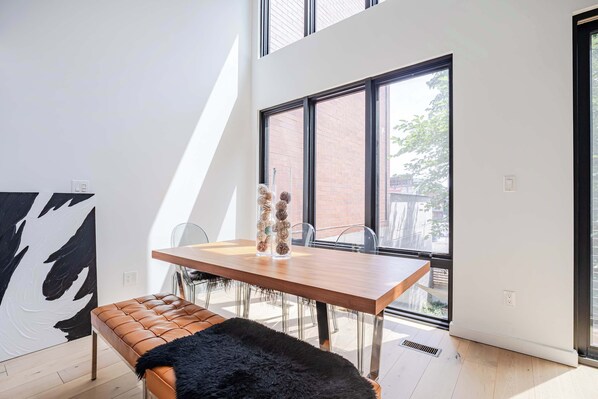 Un comedor moderno con una mesa de madera, sillas y un banco.