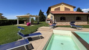 A pool area with lounge chairs and a pergola. - Ludovica and Marina Villas with 2 pools (Lajatico)
