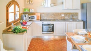 A kitchen with white cabinets, a built-in oven, a microwave, and a sink. - Ludovica and Marina Villas with 2 pools (Lajatico)