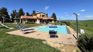 A house with a swimming pool, lounge chairs, and a slide. - Ludovica and Marina Villas with 2 pools (Lajatico)
