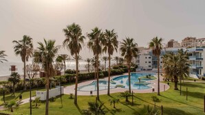 A pool area with palm trees and a view of the sea. - RentitSpain Castell Beach, Views, and Parking (Castell de Ferro)