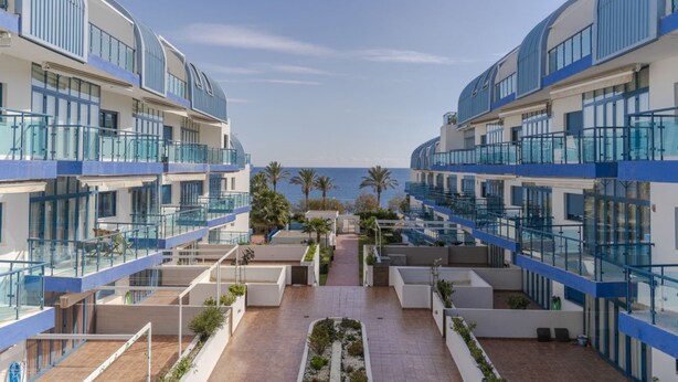A modern hotel with multiple balconies, a central courtyard, and a view of the sea. - RentitSpain Castell Beach, Views, and Parking (Castell de Ferro)