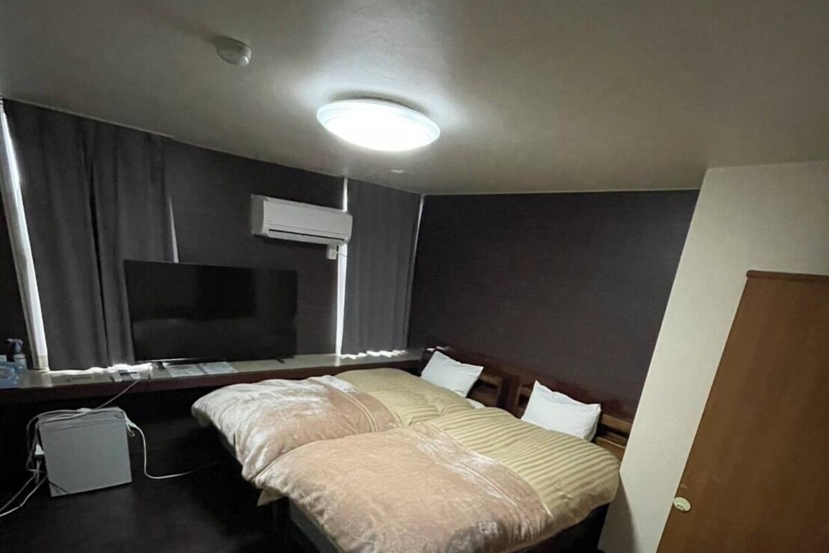Una habitación de hotel con cama, televisión, escritorio y un pequeño rincón de descanso.