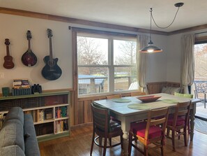 Ein Essbereich mit Tisch, Stühlen, einem Bücherregal und einem Fenster mit Blick.