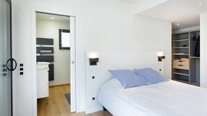 A bedroom with a bed, two wall-mounted lights, a wardrobe, and a bathroom visible through an open door. - Californian style pool villa for 10 people with air conditioning (ST AYGULF)