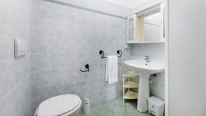 A bathroom with a toilet, sink, and shower area. - APPARTAMENTI LE PRADE - LE PRADE BILO 5 (Portoferraio)