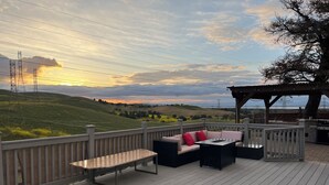 A deck with outdoor furniture, a pergola, and a view of rolling hills and power lines. - 3-bedroom Charming Home in the Hills of Pittsburg with hillside view & pool (Pittsburg)