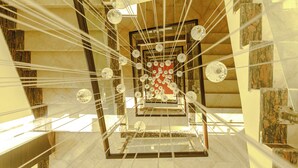 A grand staircase with multiple levels, clear glass railings, and a central red circular design. - Bodhi Redsun – Gateway to Lumbini, Comfort in Bhairahawa (Basantapur)