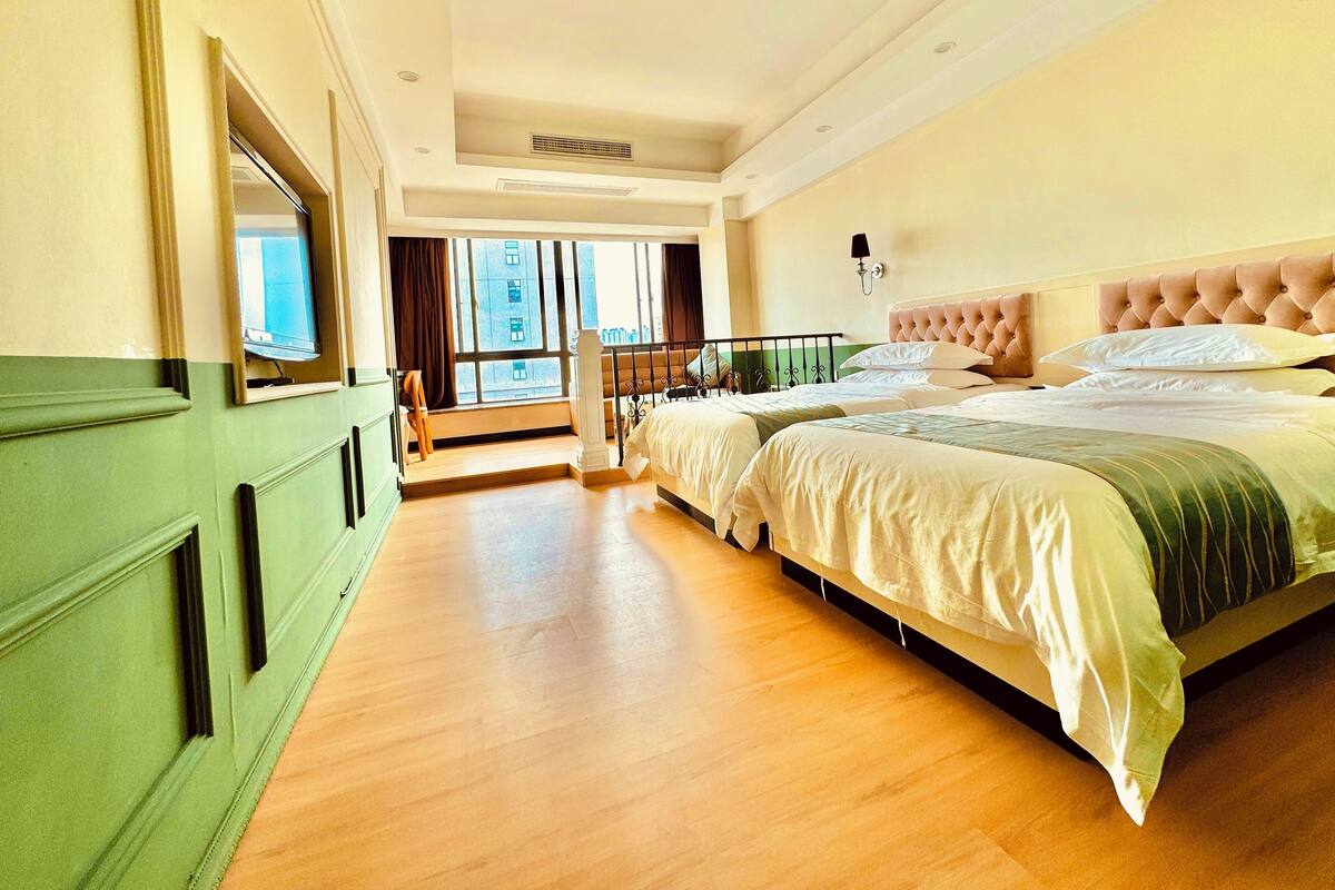 A hotel room with a large bed, a view of the city, and a balcony.