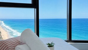 A room with a bed, a window with a view of the ocean, and a small potted plant. - Ocean Beachfront Luxe Escape at Surfers Paradise Parking (Surfers Paradise)