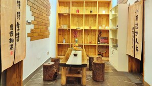 Interior japonês tradicional com estantes de madeira, uma mesa central e banquetas.