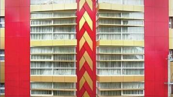 Ein Hotel mit roter Fassade und Zickzack-Muster im mittleren Bereich.