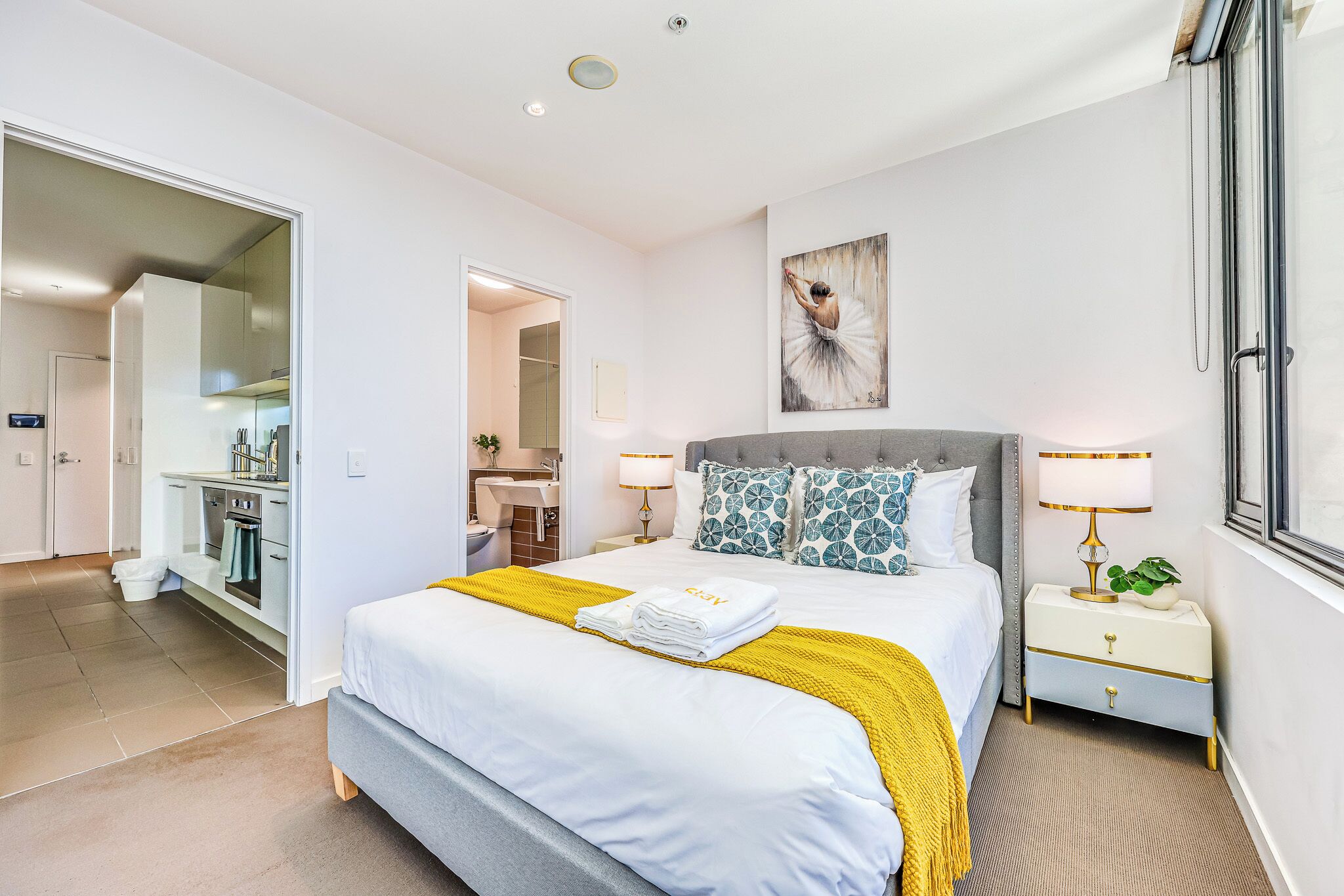 Una camera da letto moderna con un letto grande, un comodino con una lampada e un quadro appeso al muro.