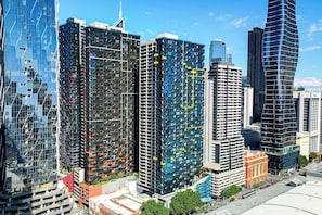 A high-rise urban area with modern skyscrapers, including a building with a unique facade and another with a curved design.