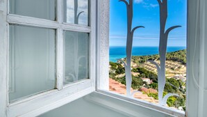 A window with white frames and frosted glass panes, offering a view of a coastal landscape with buildings and a clear blue sky. - CALMA: Spectacular holiday rental villa with private pool and sea views in Sa Riera, Begur. (Begur)