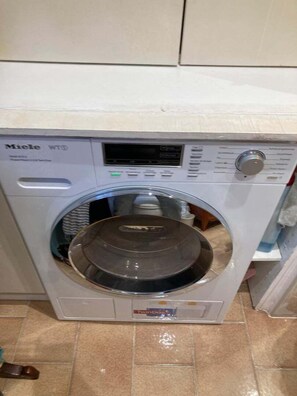 A front-loading Miele washing machine with a control panel and a transparent door. - The Persian Lady Latin Quarter by Mon Petit Faré (Paris)