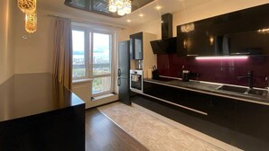 A modern kitchen with a large window, a built-in oven, and a black countertop. - HomeApatr Dzerzhinsky Ave (Minsk)
