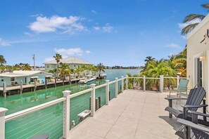 A waterfront property with a dock, a pool, and outdoor seating.