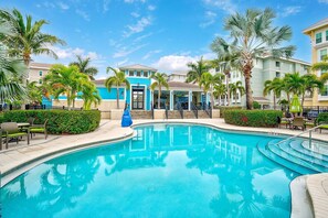 A swimming pool surrounded by palm trees and buildings with a blue and white color scheme. - Margaritaville Condo, Gated Resort, Pool & Beach! (Bradenton)