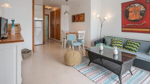 Ein modernes Wohnzimmer mit Sofa, Couchtisch und Essbereich.