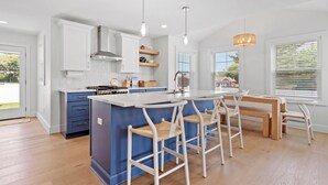 A modern kitchen with a central island, bar stools, and pendant lighting. - Ideally located, game room, finished basement, fenced yard, lawn games, coffee (Middletown)