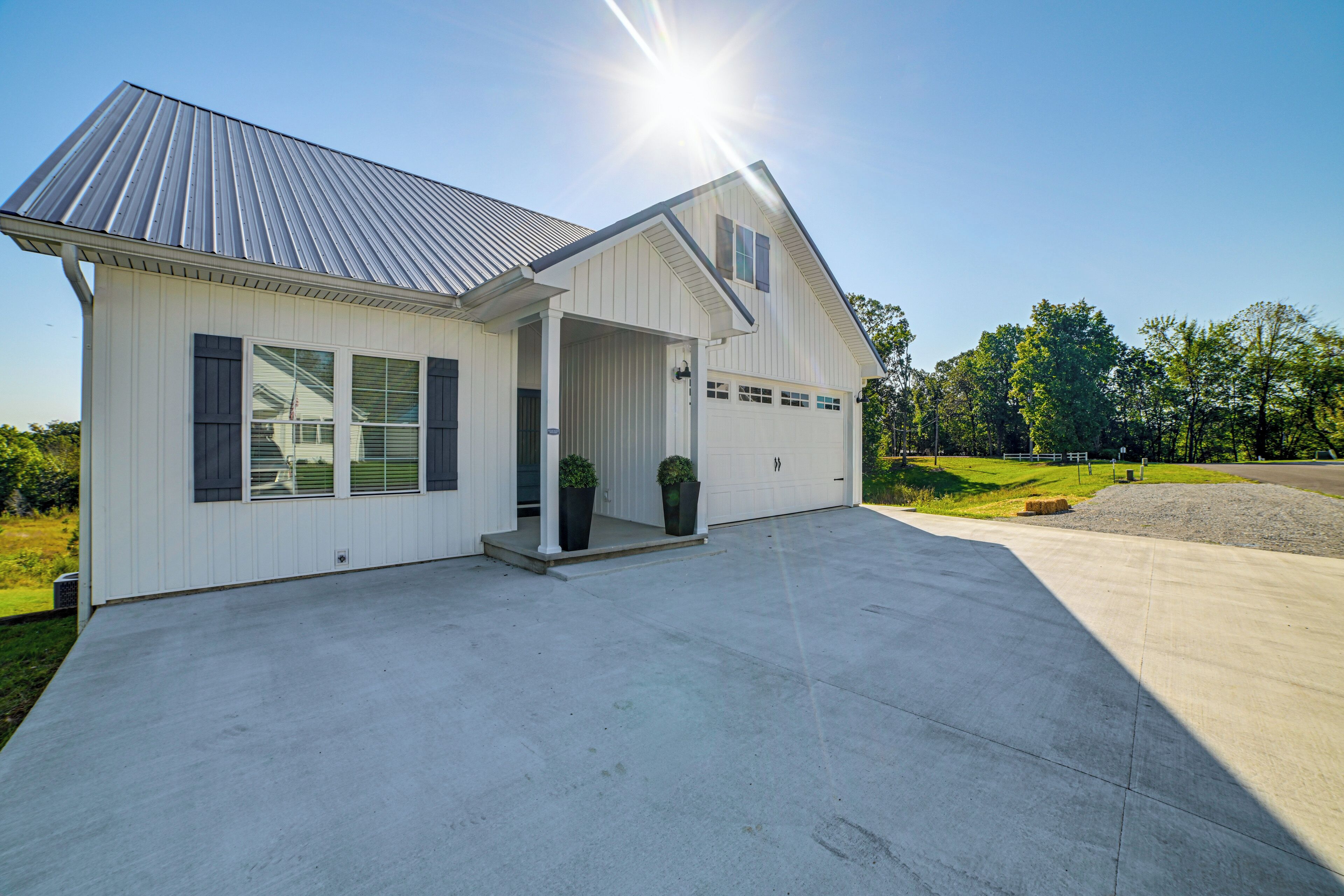 A single-story house with a garage, a covered porch, and a concrete driveway.