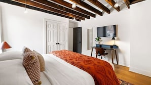 Una camera da letto con un letto, una scrivania e una televisione.