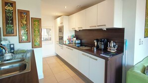 A modern kitchen with white cabinets, a stainless steel sink, and a coffee maker. - 1 Bed Flat - Sleeps 5 - Pets - Garden - Parking (Manchester)