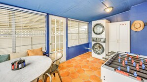 Une buanderie équipée d’un lave-linge, d’un sèche-linge et d’une table de baby-foot.
